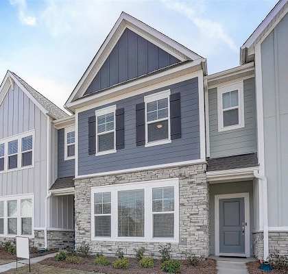 a row of townhomes with gray siding and a gray door