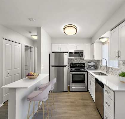 A modern kitchen with a white island and stainless steel appliances.