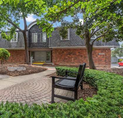a brick house with a brick walkway and a bench