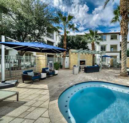 A swimming pool surrounded by palm trees and lounge chairs at Monument, Chandler