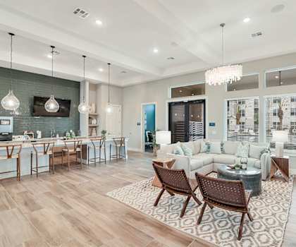 A modern living room with a kitchen area in the background.