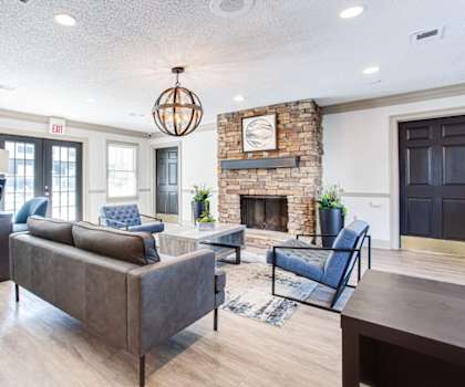 A living room with a grey couch and a fireplace at Barcelo at East Cobb Apartments, Georgia