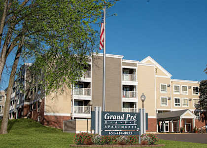 The Grand Pré apartments building has a flag on a pole in front of it.