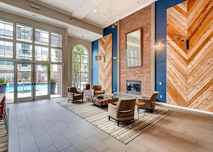 a lobby with a fireplace and chairs and a rug at Viridian in Greenwood Village, CO