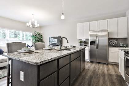 an open kitchen with granite counter tops and stainless steel refrigerator