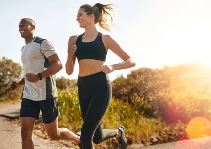 a man and a woman running down a road