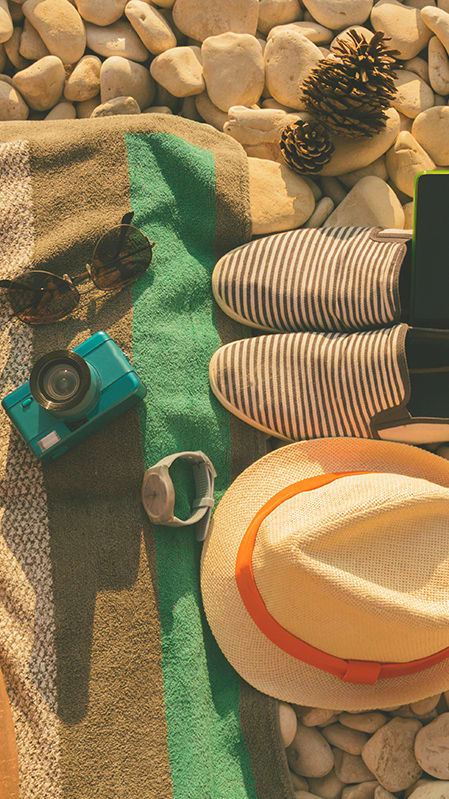 Lifestyle photo of beach bag, hat and shoes