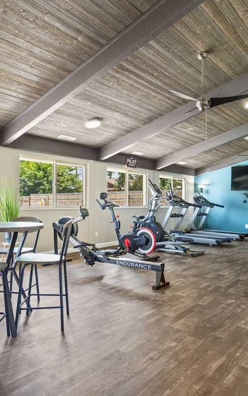a gym with exercise equipment and a door to a patio