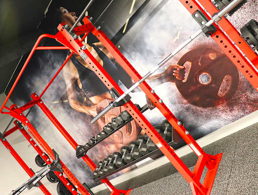 A red metal structure is holding up a poster with a man and a woman on it. at The Elle on Lockwood Apartments, Webster Groves, MO, 63119