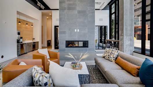 Lounge room with a fireplace and a grey sofa.