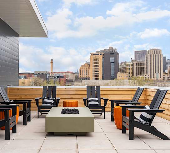 A patio with black chairs and a table with a laptop on it.