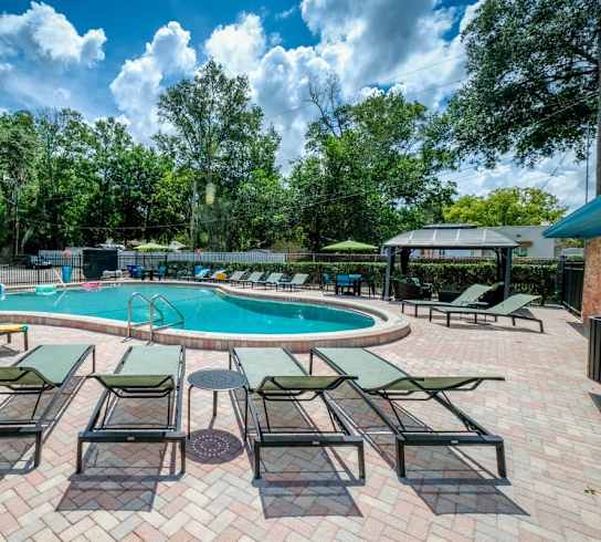 Watermarc swimming pool with chaise lounge chairs and umbrellas