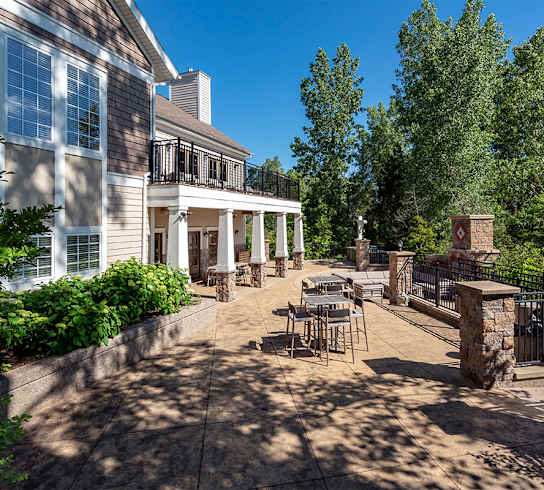 a patio with tables and chairs in front of a building