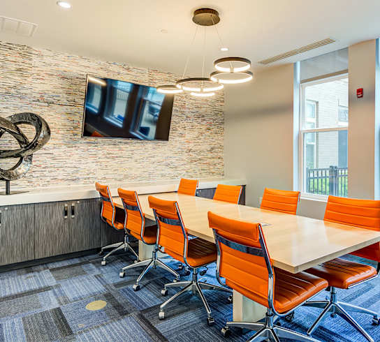 a conference room with a table and chairs and a tv on the wall at Ascend Apollo Apartments, Largo, MD, 20774