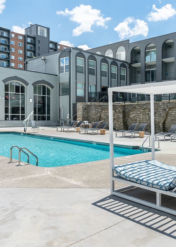 A pool with a sun lounger in front of a building. at The Heights Apartments, Cincinnati, 45220