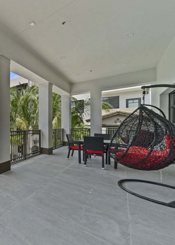 A pool surrounded by palm trees and lounge chairs.