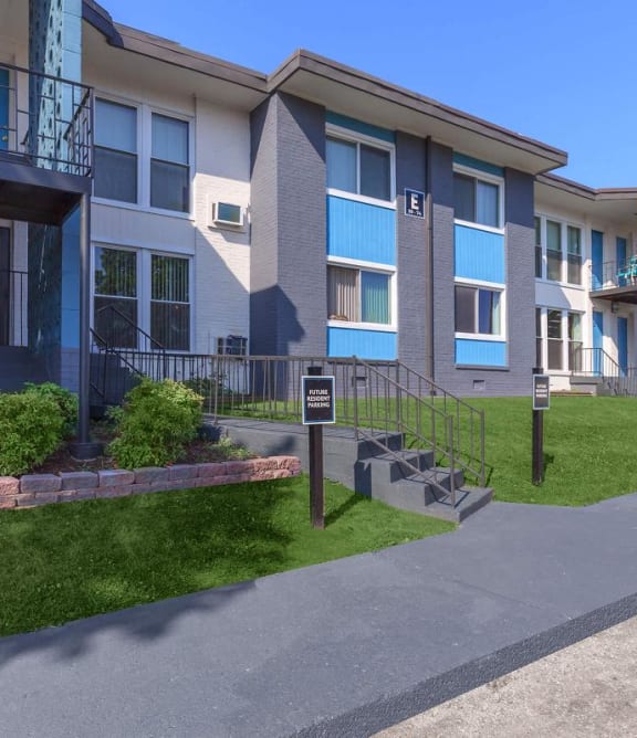 an apartment building with a sidewalk in front of it