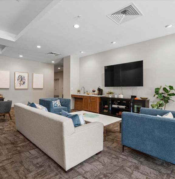 A living room with a white couch and a blue chair.