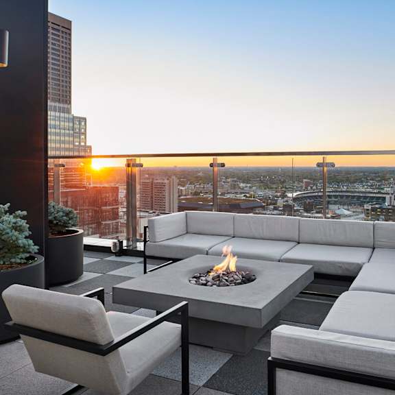 A rooftop patio with couches and a fire pit at 4Marq.