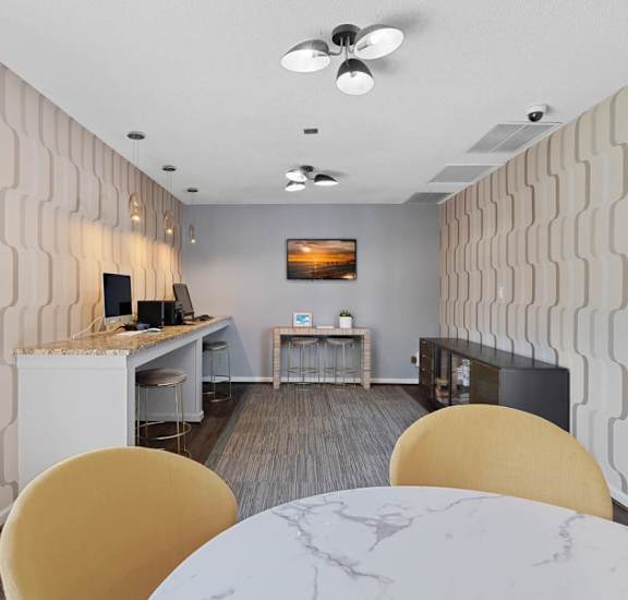 A modern dining room with a white marble table and yellow chairs.
