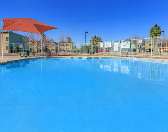 a large swimming pool with an umbrella in front of a building