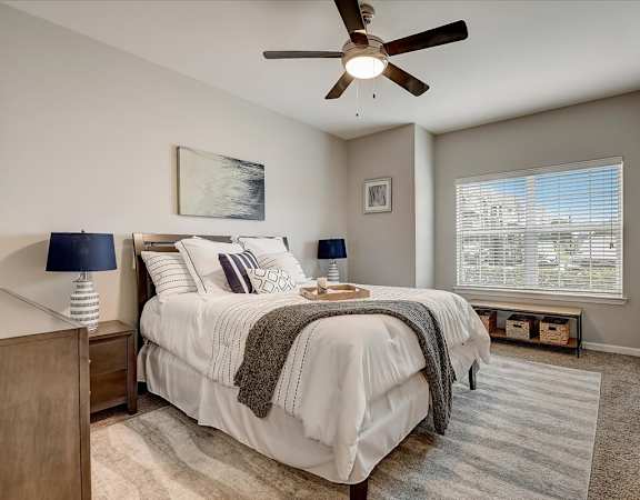 a bedroom with a bed and a ceiling fan