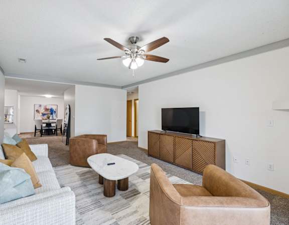 A living room with a grey couch and brown leather chairs