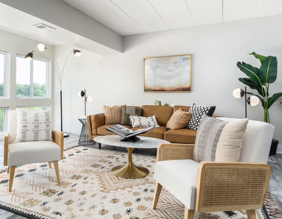 A living room with a white chair and a brown couch. at The Heights Apartments, Cincinnati, 45220