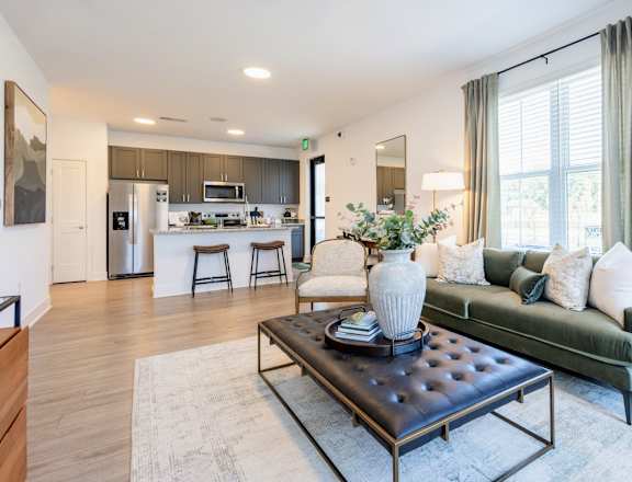 A modern living room with a dark leather coffee table and a green couch.