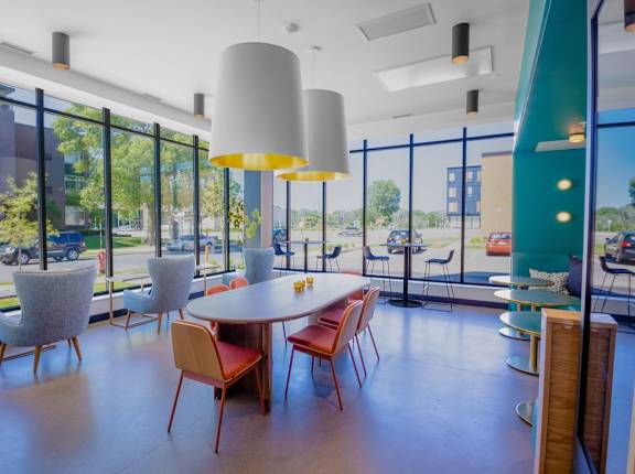 A room with a table and chairs with a view of the outside.