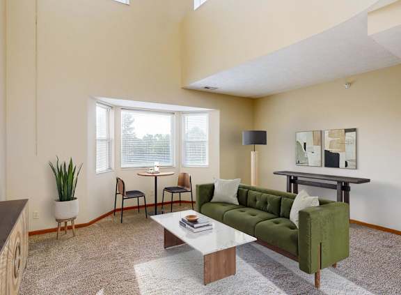 A living room with a green couch and a white coffee table.