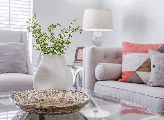 a living room with white furniture and a glass table