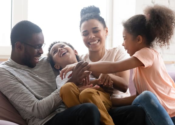 Lifestyle photo of family laughing at home at Tuscany Place Apartments, Florida