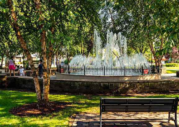 A fountain in a park with a bench in the foreground. at Vermella Lyndhurst apartments, Lyndhurst, NJ, 07071