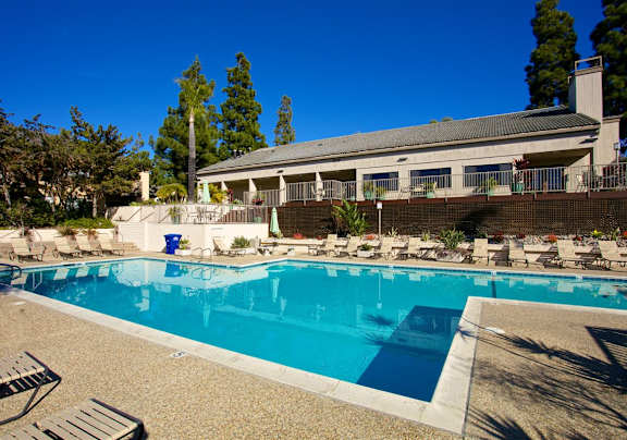 A pool with a yellow chair and a rock in the foreground.