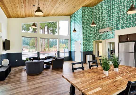 a large living room with a wooden table and chairs