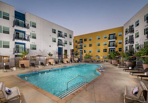 a swimming pool in the middle of an apartment building at Aston at Gateway Apartments, El Monte, California