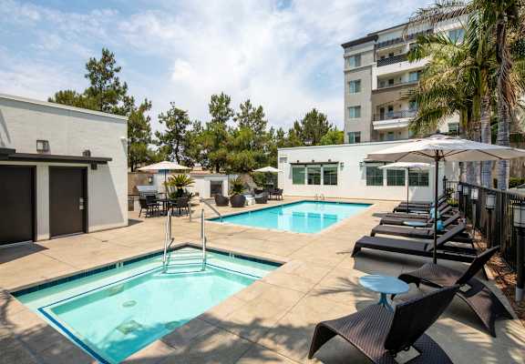 A pool with a ladder and a table with chairs.