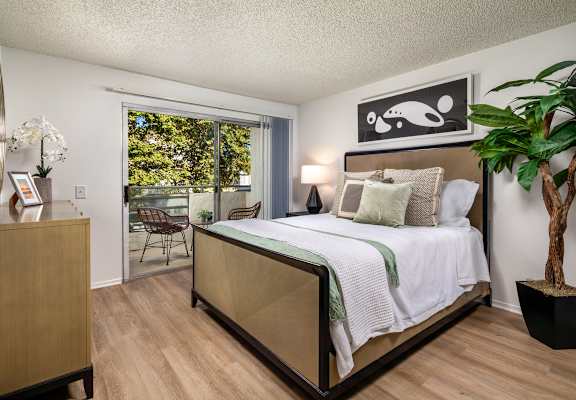 A bedroom with a large bed and a wooden dresser.