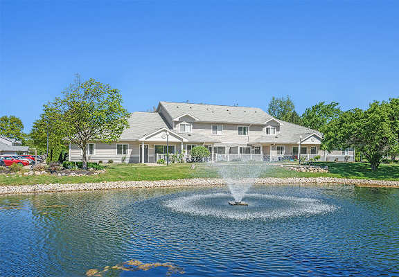 A house with a fountain in front of it.