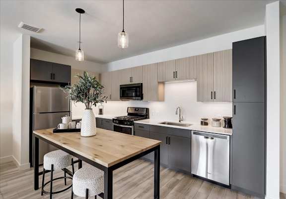 a kitchen with stainless steel appliances and a wooden table