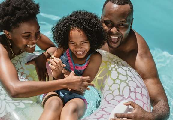 A family of three enjoying a day at the pool.