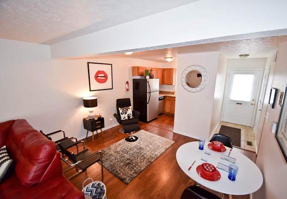 A living room with a red couch and a white table.