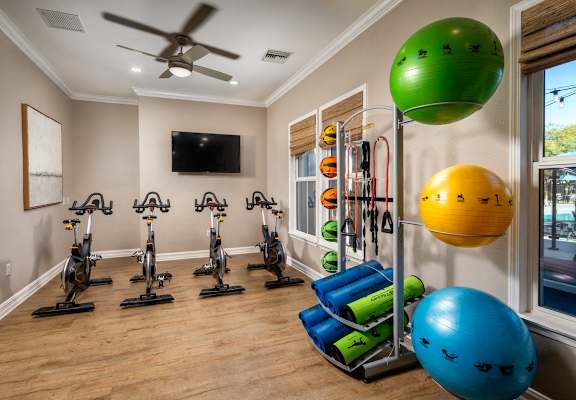 a home gym with exercise equipment and a ceiling fan