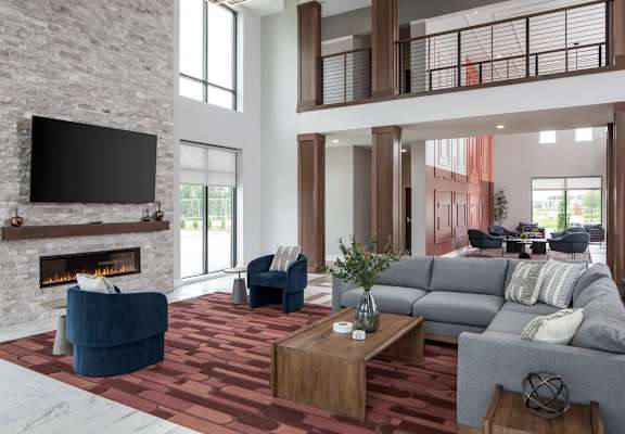 A modern living room with a fireplace and a television above it.at The Edison at Maple Grove, Maple Grove Minnesota