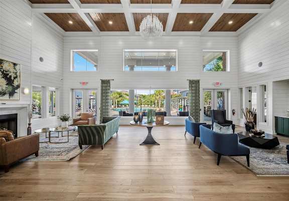 A large, well-lit living room with a fireplace and a variety of seating options.
