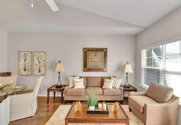 A living room with a couch, two chairs, a coffee table, and a painting on the wall.