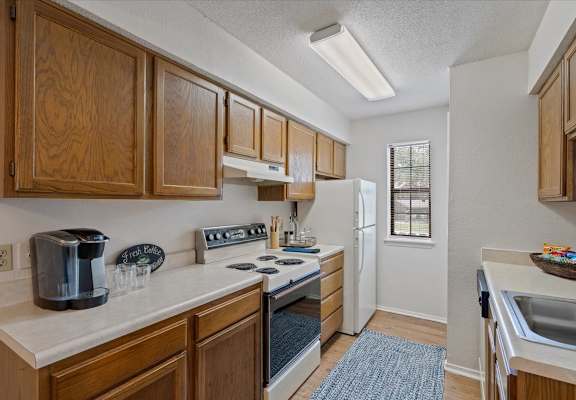 a kitchen with a white refrigerator freezer next to a stove top oven