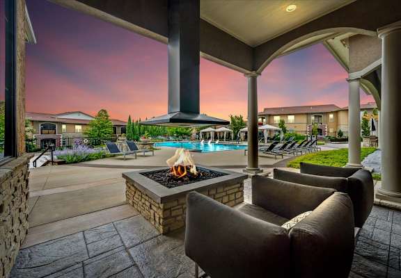 a patio with couches and a fire pit