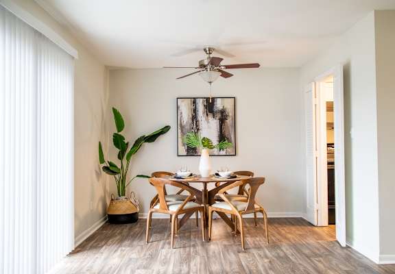 A dining room with a wooden table and chairs.